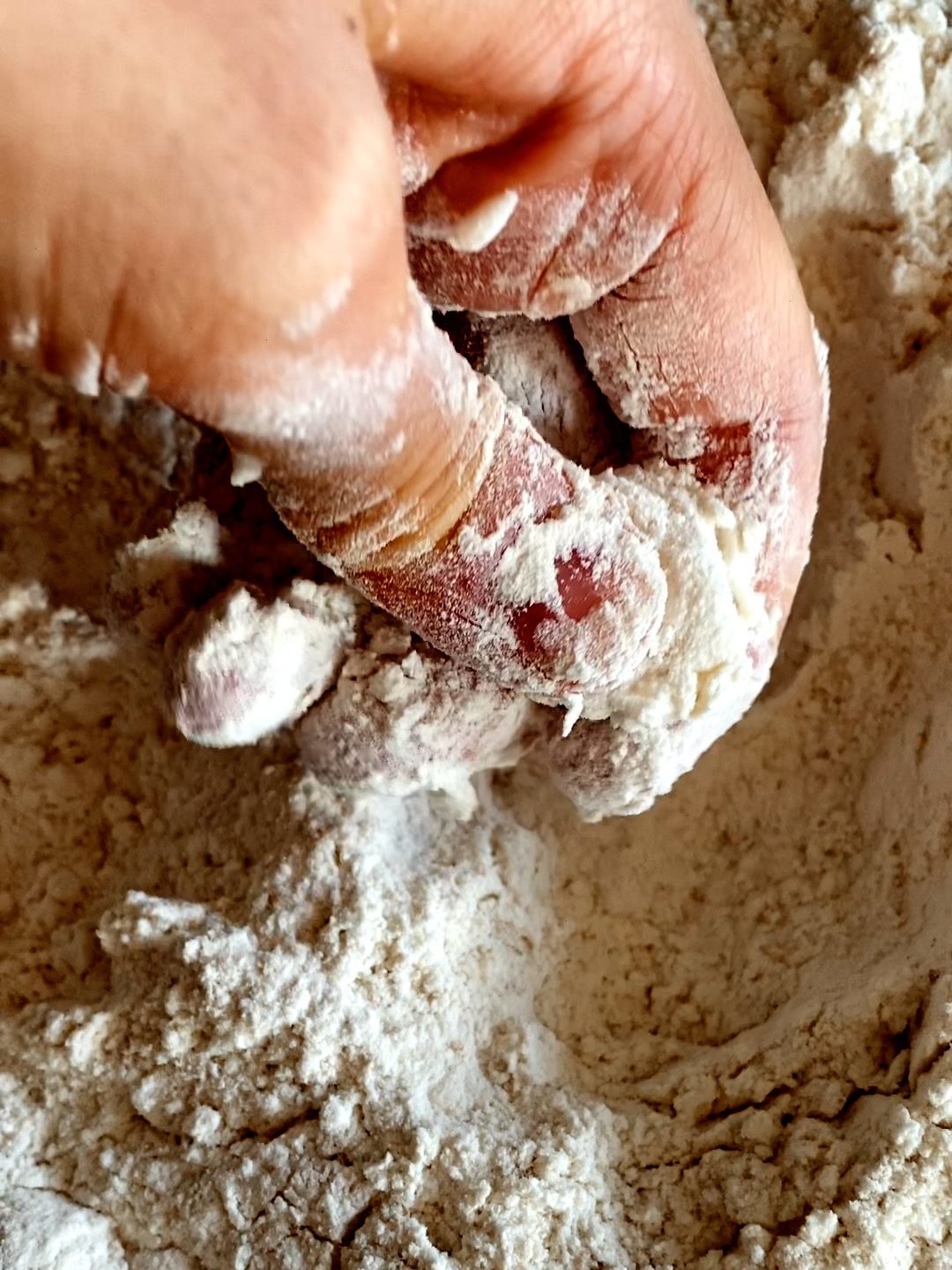 Mashing the cold butter in the dry ingredients with hands
