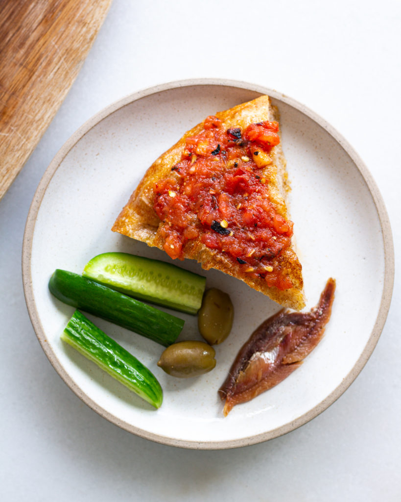 Blistered Tomato Dressing on bread with pickles, olives, and anchovies 