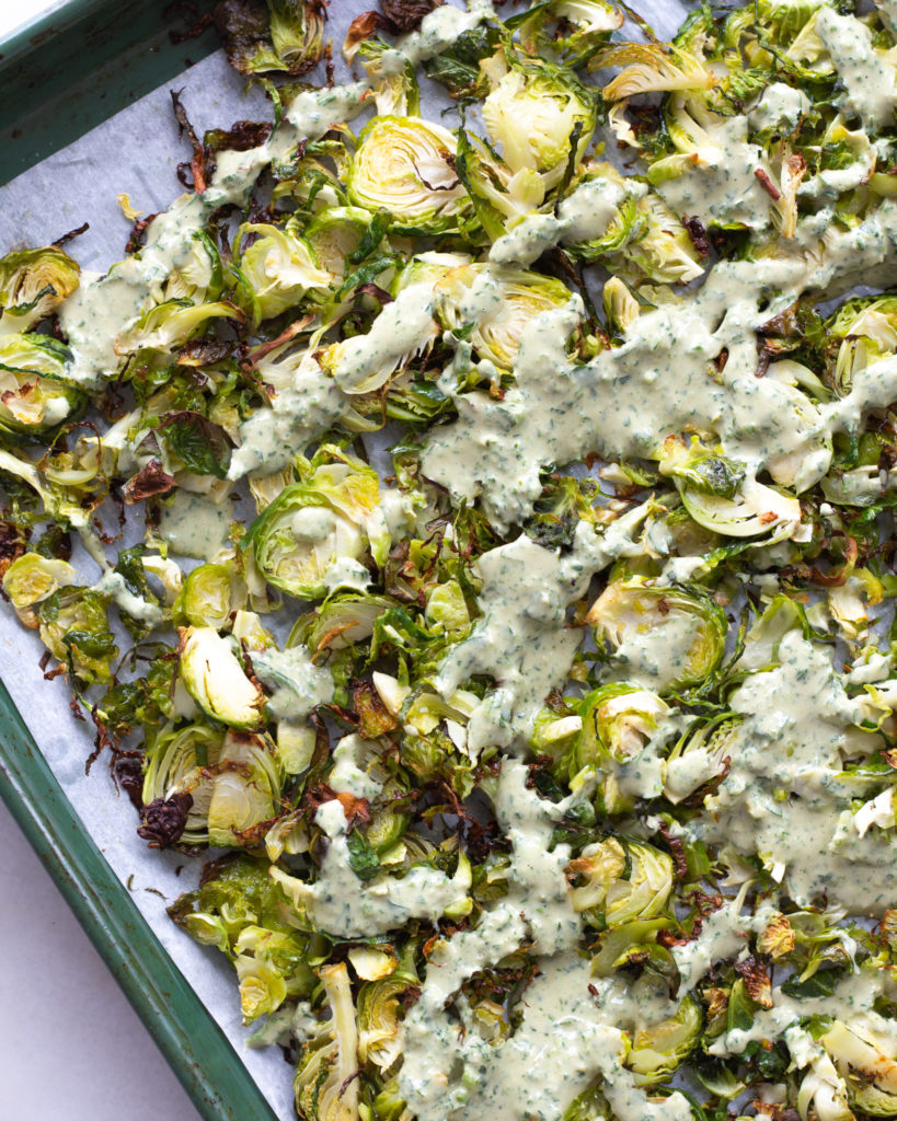 Roasted brussels sprouts with anchovy tahini dressing on top