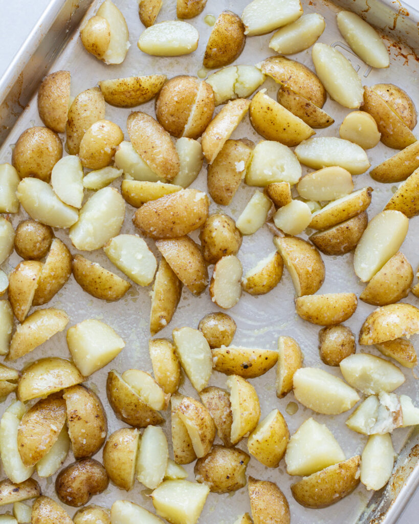 Boiled and roughed potatoes on baking sheet