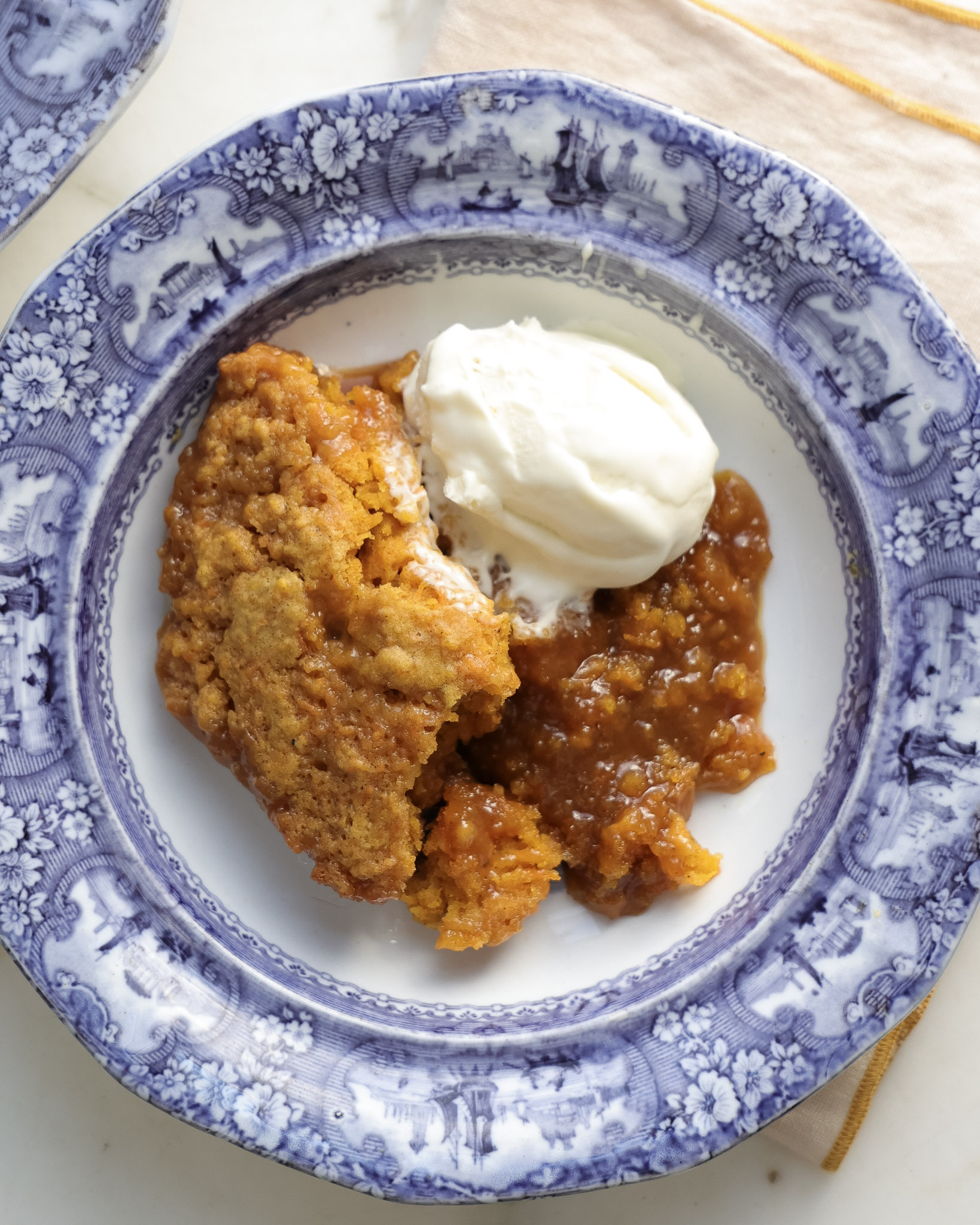 Caramel covered carrot cake served with ice cream.